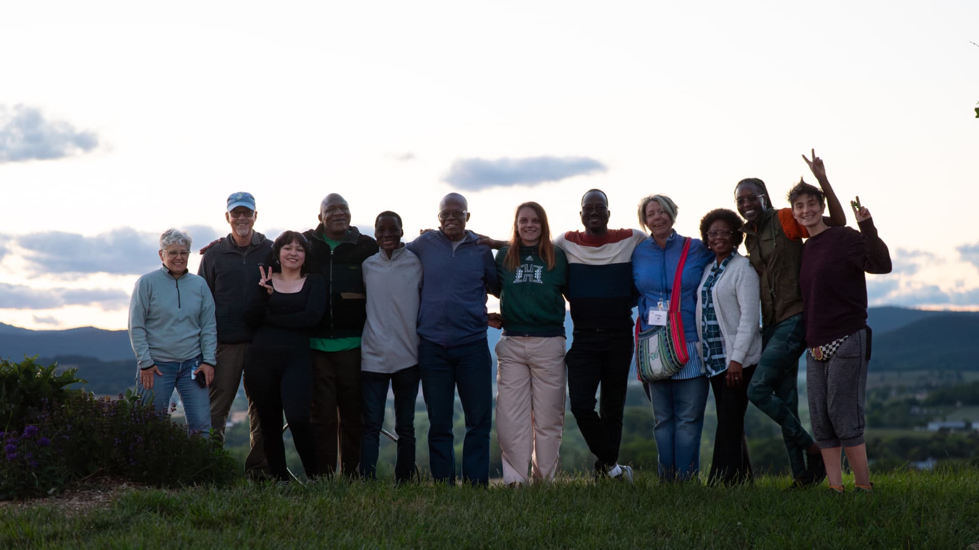 SPI peacebuilding participants gathered outdoors at sunset